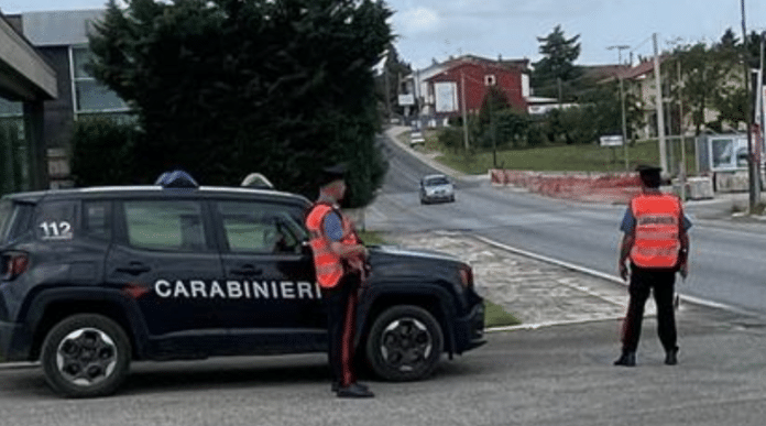 Posto di blocco con più Carabinieri intenti a controllare documenti di automobilisti